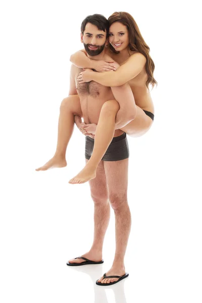 Man carrying girlfriend on his back. — Stock Photo, Image