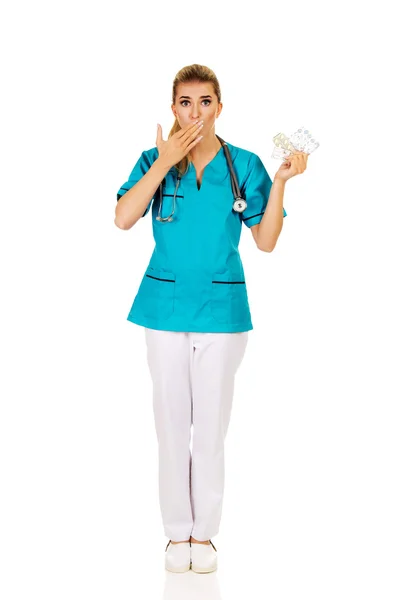 Schockierte Krankenschwester oder Ärztin mit Tabletten — Stockfoto