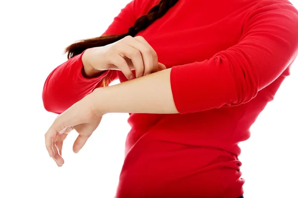 Jonge vrouw krabben van haar hand — Stockfoto