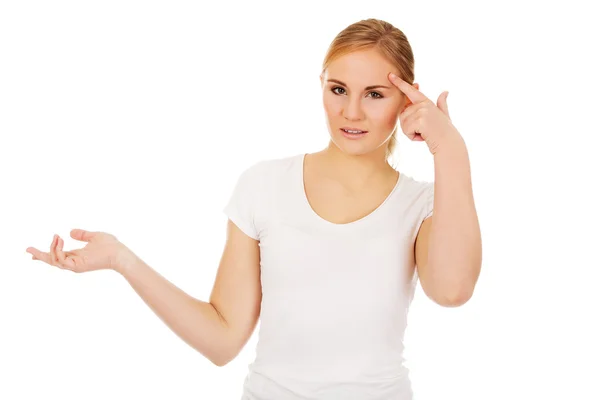 Young woman holding something on open palm and thinking about something — Stock Photo, Image