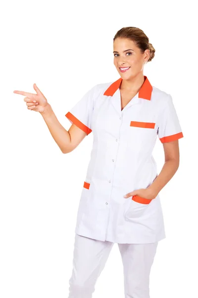 Uśmiechnięta kobieta lekarz lub pielęgniarka wskazując na coś — Zdjęcie stockowe
