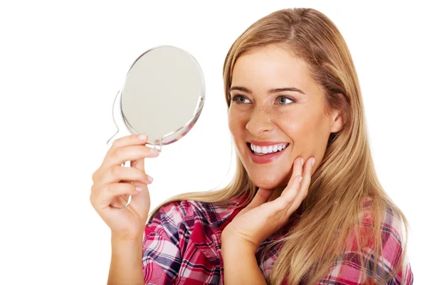 Jonge lachende vrouw die een spiegel vasthoudt — Stockfoto
