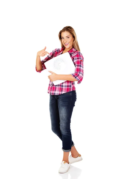 Smiling young woman holding a scale — Stock Photo, Image