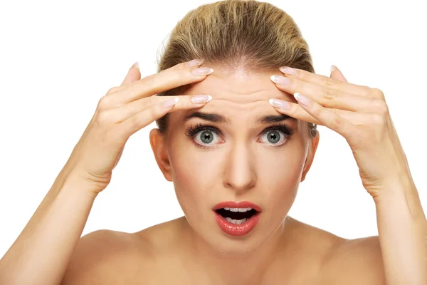 Egy fiatal nő, ráncok a homlokán ellenőrzése — Stock Fotó