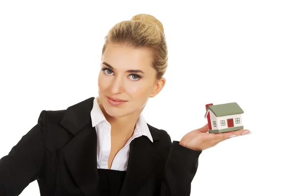 Empresária feliz segurando um modelo de casa — Fotografia de Stock