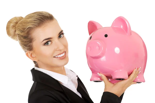 Junge Geschäftsfrau spart Geld in Sparschwein — Stockfoto