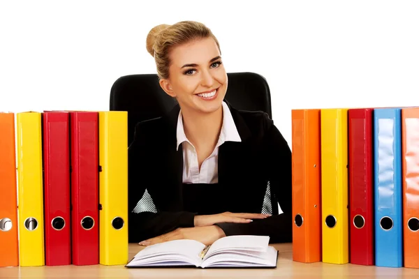 Donna d'affari sorridente con leganti da una scrivania — Foto Stock