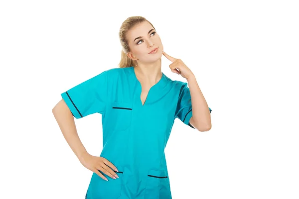 Sorridente infermiera di sesso femminile pensando a qualche idea — Foto Stock