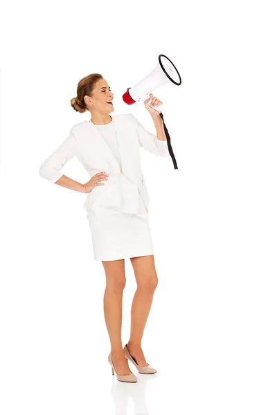 Beautiful businesswoman screaming through megaphone — Stock Photo, Image