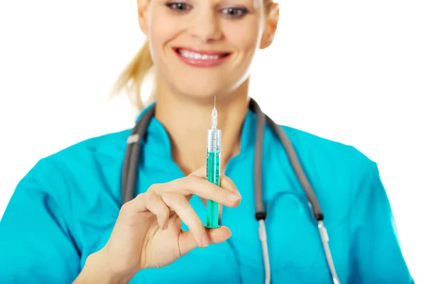 Vrouwelijke arts of verpleegkundige glimlachend met stethoscoop houden spuit — Stockfoto