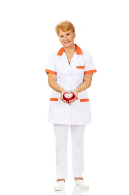 Yaşlı kadın doktor gülümseme ya da hemşire çalar saat tutar