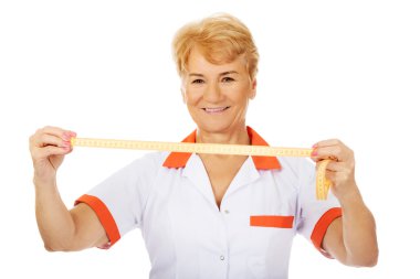 Yaşlı doktor gülümseme ya da hemşire ölçüm bandı tutar