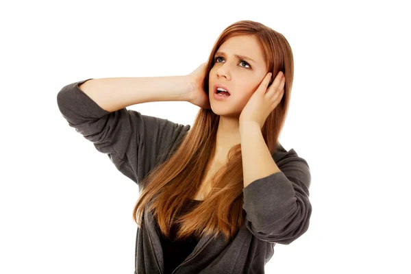 Boos tiener vrouw die betrekking hebben op oren met handen — Stockfoto