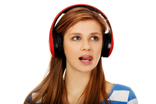 Kobietę nastoletnia słucha muzyki i pokazuje język — Zdjęcie stockowe