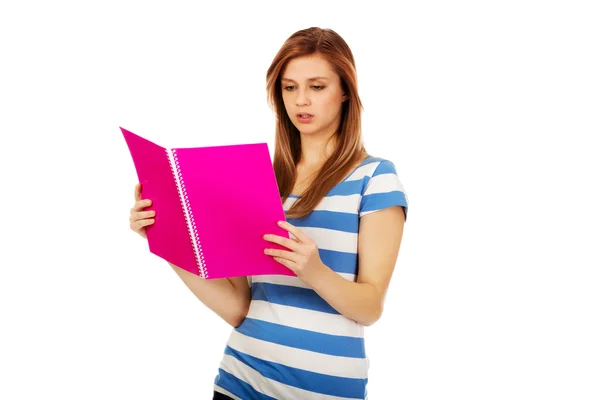 Femme adolescente souriante lisant ses notes — Photo