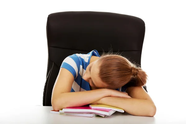 Adolescente épuisée dormant sur le bureau — Photo