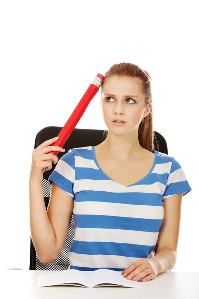 Hezká dospívající žena drží obrovský tužka. — Stock fotografie