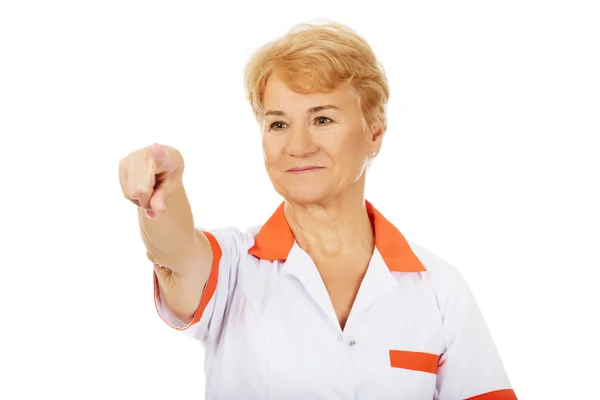 Smile elderly female doctor or nurse pointing at camera — Stock Photo, Image