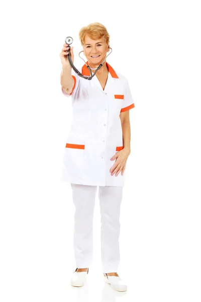 Starší ženský doktor úsměv drží stetoskop — Stock fotografie