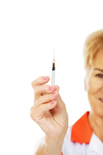 Smile elderly female doctor or nurse holds syringe — Stock Photo, Image