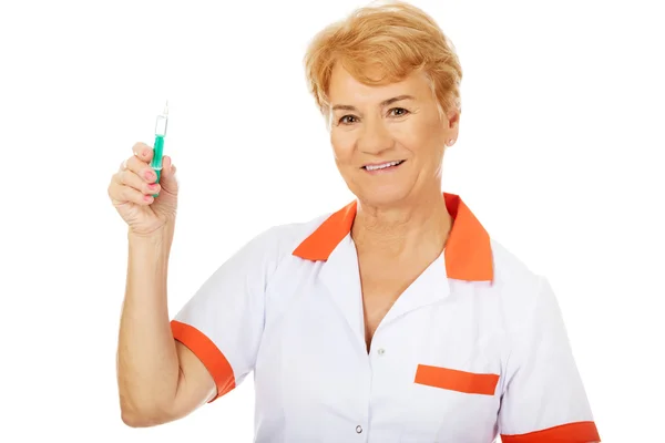 Sorriso anziano donna medico o infermiere tiene siringa — Foto Stock