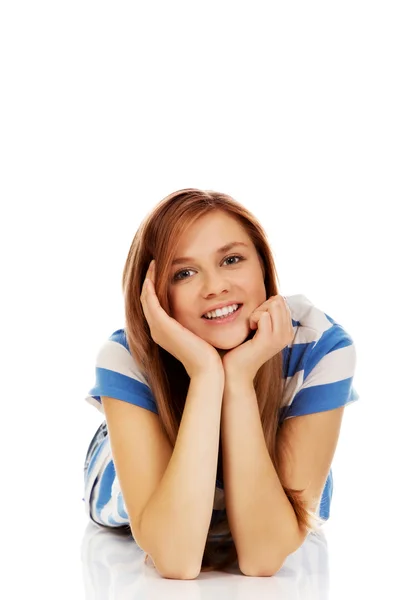 Smiling teenage woman lying on floor Royalty Free Stock Photos