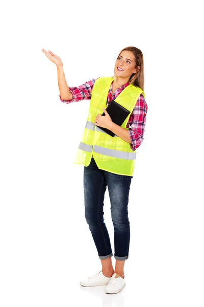 Vrouwelijke bouwer in een helm en een vest met een notebook — Stockfoto