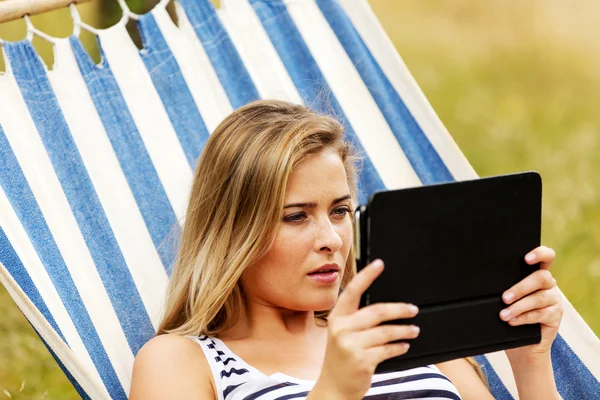 Jonge vrouw met tablet op de hangmat — Stockfoto