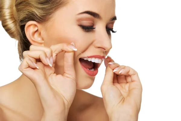 Ung kvinna tandtråd tänderna. — Stockfoto