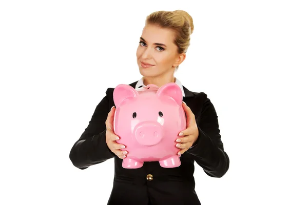 Glückliche Geschäftsfrau spart Geld in Sparschwein — Stockfoto