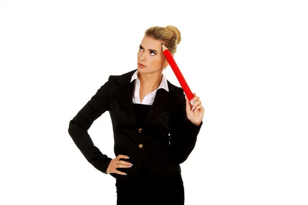 Young businesswoman thinking with big pen — Stock Photo, Image