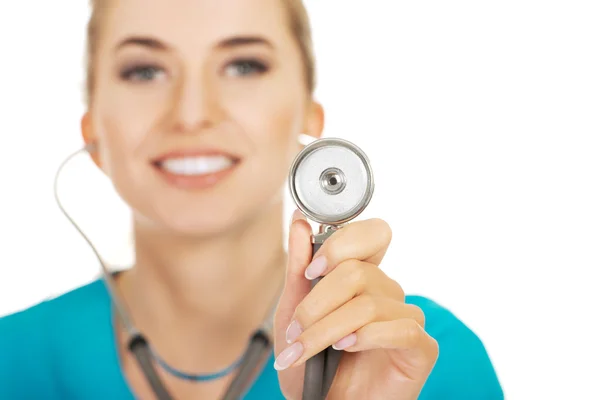 Médica sorridente segurando um estetoscópio — Fotografia de Stock