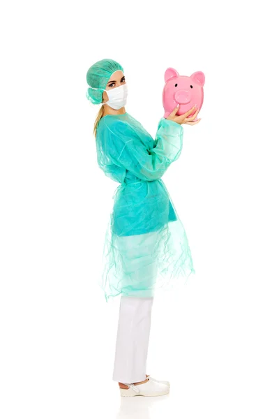 Médico cirujano femenino sosteniendo alcancía — Foto de Stock