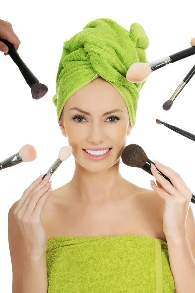 Young woman has brushes around face. — Stock Photo, Image