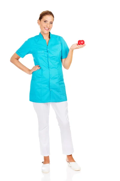 Młoda kobieta lekarz lub pielęgniarka gospodarstwa serca zabawka — Zdjęcie stockowe