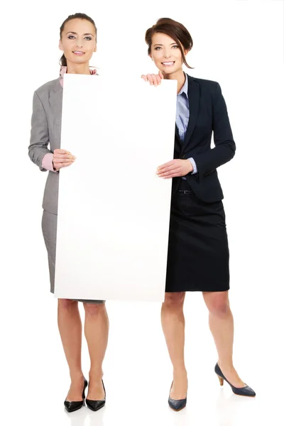 Zwei Geschäftsfrauen mit einer großen weißen Tafel. — Stockfoto