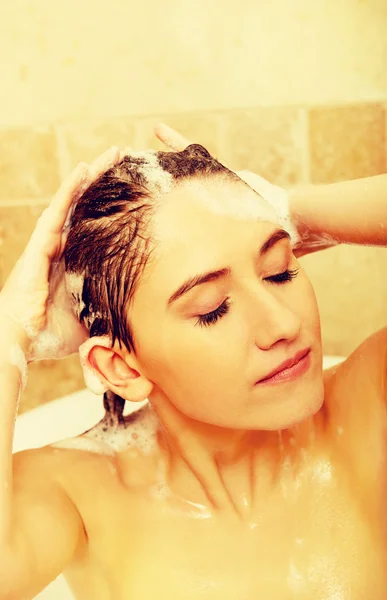 Jovem mulher relaxante lavar o cabelo no banho — Fotografia de Stock