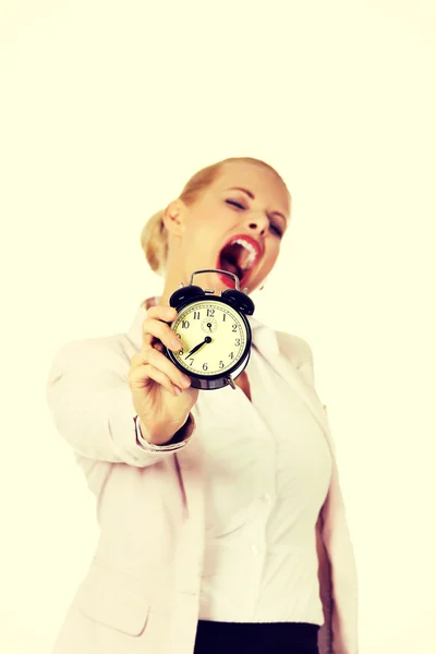 目覚まし時計を保持しているあくびのビジネス女性 — ストック写真