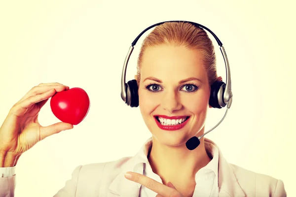 Feliz call center mulher segurando coração brinquedo — Fotografia de Stock