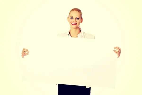 Sorrindo jovem empresária segurando banner em branco — Fotografia de Stock