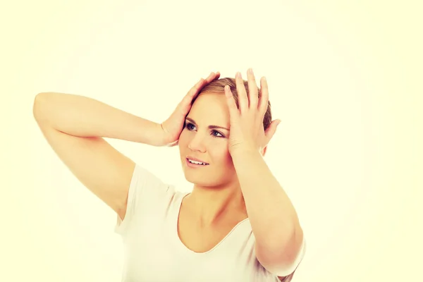 Junge Frau mit Kopfschmerzen hält ihre Hand an den Kopf — Stockfoto