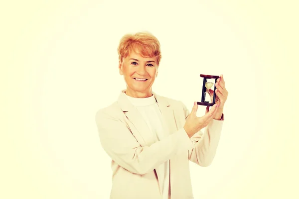 Smile elderly  business woman holding sandglass — Stock Photo, Image