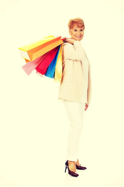 Feliz anciana mujer de negocios sosteniendo bolsas de compras — Foto de Stock