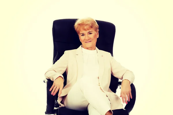 Smile elderly business woman sitting on armchair — Stock Photo, Image