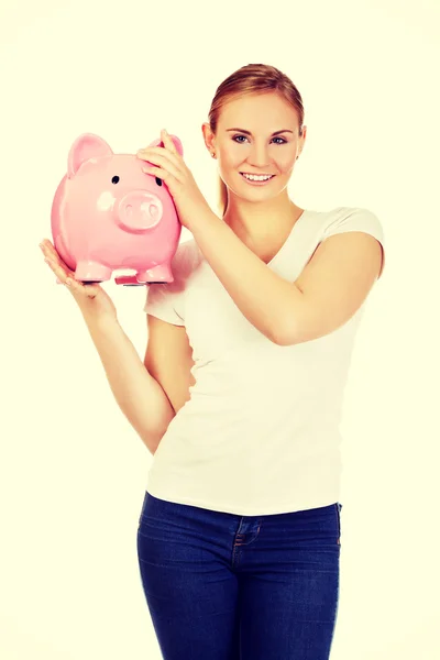 Glückliche junge Frau hält Sparschwein — Stockfoto