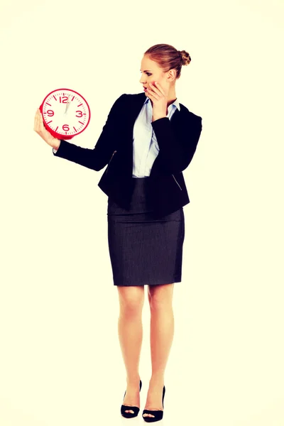 Γυναίκα σε εργασία σοκαρισμένος κρατώντας ρολόι γραφείου — Φωτογραφία Αρχείου