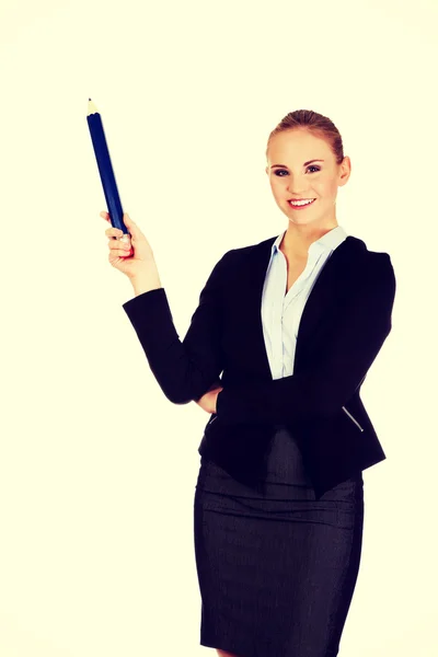 Business woman pointing for copyspace or something with huge pen — Stock Photo, Image
