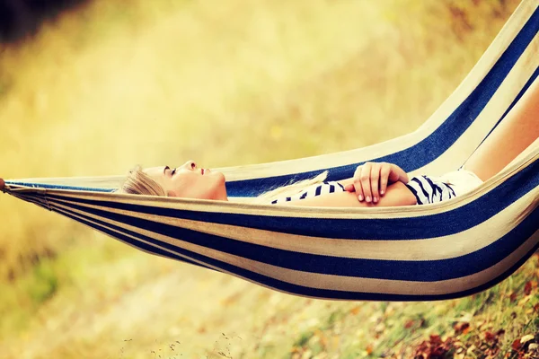 Mujer rubia joven descansando en la hamaca — Foto de Stock