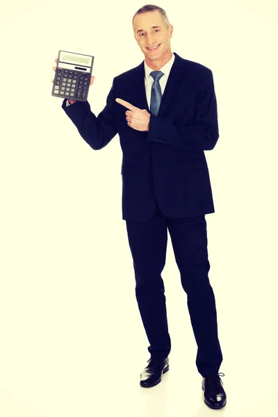 Happy businessman pointing on calculator — Stock Photo, Image