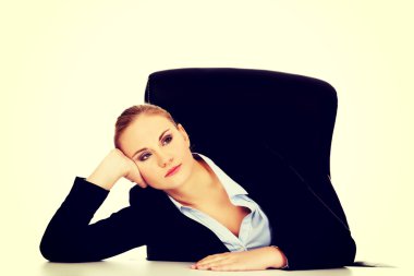 Masanın arkasında oturan yorgun iş kadını